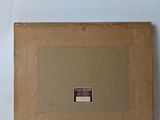 an old picture of a box with a label on it sitting on a white surface