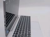 a silver laptop with a black keyboard on a white surface