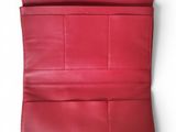 a red leather wallet with a zipper on the inside