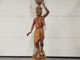 a statue of a man holding a pot on his head