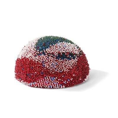 Le chapeau orné de perles est rouge, blanc et bleu.