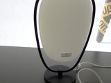 une lampe posée sur une table à côté d'un téléphone portable
