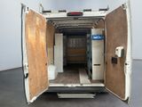 the back of a white van with its doors open and a mattress in the back