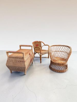 deux fauteuils en osier et un pouf dans une pièce aux murs blancs