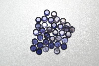 un gros plan sur un bouquet de saphirs bleus posés sur une surface blanche