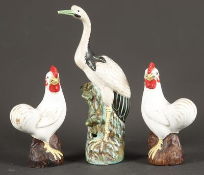 three figurines of birds sitting on top of a tree stump
