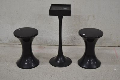deux tabourets noirs placés l'un à côté de l'autre sur un sol en béton