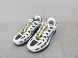 pair of white and blue sneakers with yellow laces on a gray surface