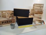 many wooden crates on a table with a chalk board