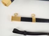a black and gold belt and a black and gold purse