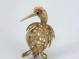 an image of a gold bird broochle with ruby eyes