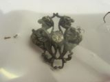 a small metal object that is sitting on a white plate
