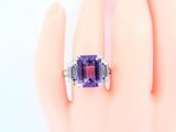 an image of a woman ' s hand with a purple ring on it