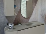 une salle de bains équipée d'un lavabo, d'un miroir et d'un tapis au sol