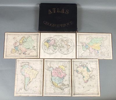 six cartes du monde posées sur une table, à côté d'une boîte noire