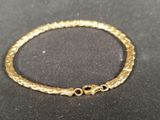 a close up of a gold bracelet on a black surface