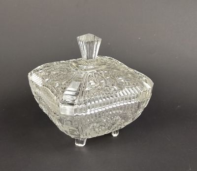 une boîte en verre transparent avec un couvercle, posée sur une table
