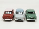 four toy cars are lined up in a row on a white surface