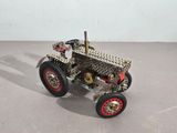 a toy car made out of metal with a red wheel