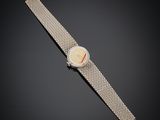a lady ' s wrist watch with a white dial and silver mesh band