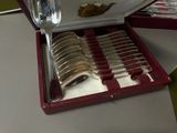 silverware in a red case on a table with a bowl and spoon