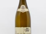 une bouteille de vin blanc posée sur une table blanche