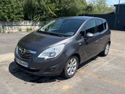 une voiture grise garée sur un parking, avec des arbres en arrière-plan