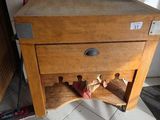 un petit meuble en bois surmonté d'un casier à bouteilles