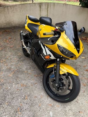 a yellow and black motorcycle parked in a parking lot
