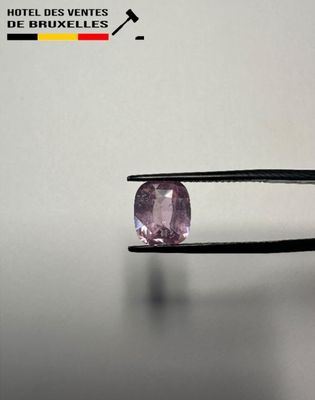 a close up of a person holding a pair of pliers with a pink diamond