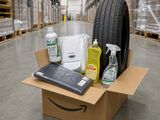 une caisse remplie de produits d'entretien posée à même le sol d'un entrepôt