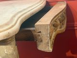 a wooden table with a marble top on a red wall
