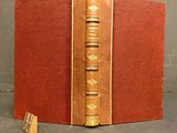 an old book sitting on top of a table next to a small piece of paper