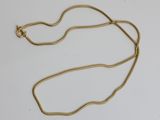 un collier plaqué or avec une longue chaîne sur un fond blanc