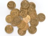 some gold coins are scattered on a white surface with a white background