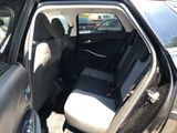 a black car with its door open in a parking lot