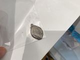 a person holding a piece of paper with a coin on it