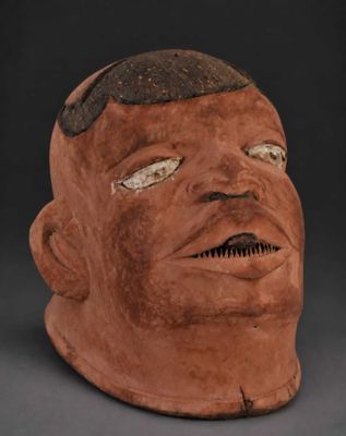 a clay mask with a black face and brown hair