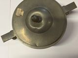 a small metal object on a table with a piece of paper