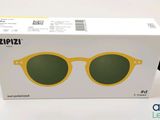une boîte sur laquelle est posée une paire de lunettes de soleil jaunes