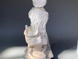 a small statue of a woman holding a basket
