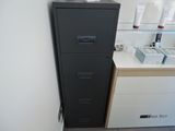 a black filing cabinet in the corner of a room