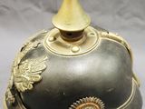 an old helmet with a gold decoration on the top of it