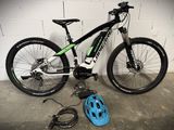 a bicycle that is sitting on the ground next to a helmet
