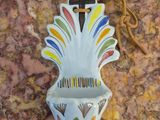 un petit vase orné d'une croix, posé sur une table