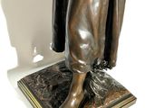 bronze statue of a woman holding a cat on a marble base