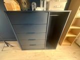 a black dresser in the corner of a room