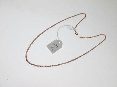 une photo d'un collier muni d'une étiquette, posé sur une surface blanche