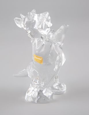 une figurine en verre représentant un dinosaure, munie d'une étiquette