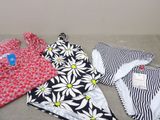 several women ' s swimsuits are laid out on a couch